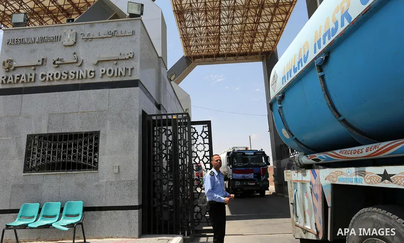 A member of Palestinian security forces stands guard as Egyptian trucks carrying fuel enter the southern Gaza Strip from Egypt through the Rafah border crossing on June 21, 2017. Egypt began to deliver a million litres o...