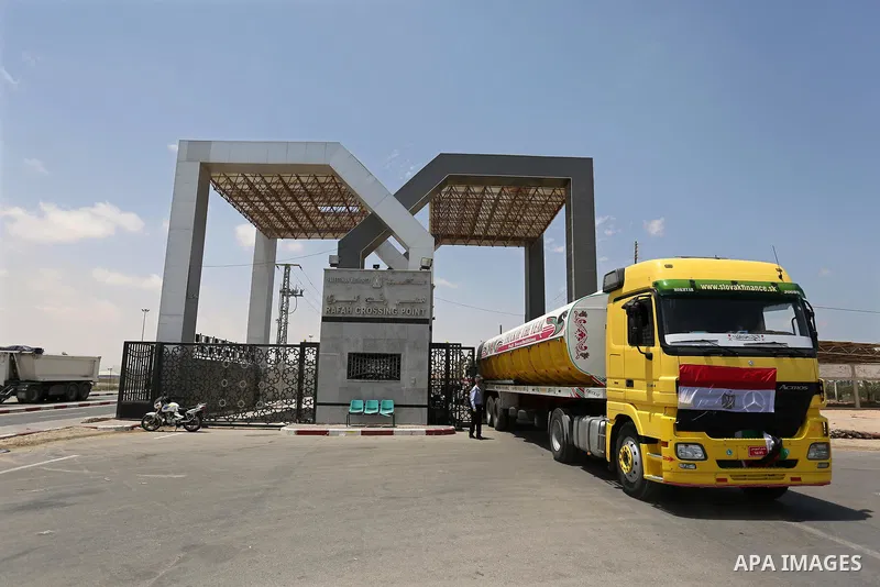 A member of Palestinian security forces stands guard as Egyptian trucks carrying fuel enter the southern Gaza Strip from Egypt through the Rafah border crossing on June 21, 2017. Egypt began to deliver a million litres o...