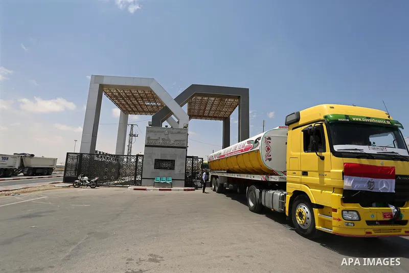 A member of Palestinian security forces stands guard as Egyptian trucks carrying fuel enter the southern Gaza Strip from Egypt through the Rafah border crossing on June 21, 2017. Egypt began to deliver a million litres o...