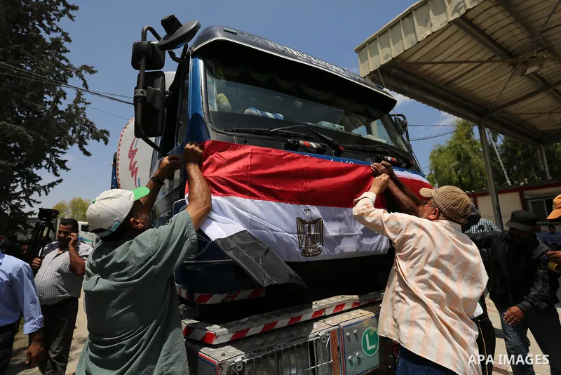 Palestinians put the national flag and Egyptian flag on an Egyptian truck carrying fuel after it was enter the southern Gaza Strip from Egypt through the Rafah border crossing on June 21, 2017. Egypt began to deliver a m...