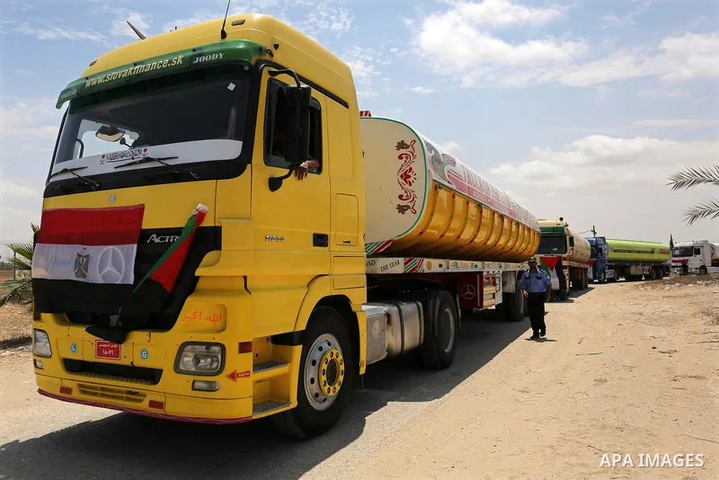 A member of Palestinian security forces stands guard as Egyptian trucks carrying fuel enter the southern Gaza Strip from Egypt through the Rafah border crossing on June 21, 2017. Egypt began to deliver a million litres o...