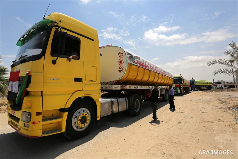 Palestinian security forces stand guard as Egyptian trucks carrying fuel enter the southern Gaza Strip from Egypt through the Rafah border crossing on June 21, 2017. Egypt began to deliver a million litres of fuel to Gaz...
