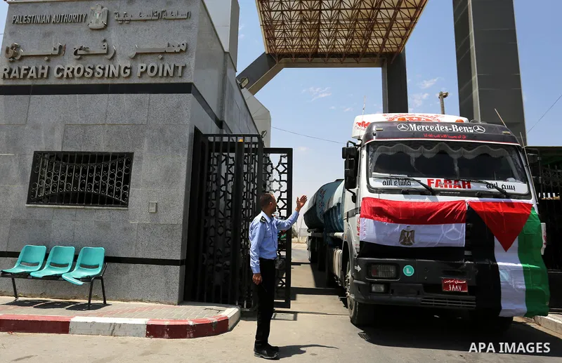 A member of Palestinian security forces stands guard as Egyptian trucks carrying fuel enter the southern Gaza Strip from Egypt through the Rafah border crossing on June 21, 2017. Egypt began to deliver a million litres o...