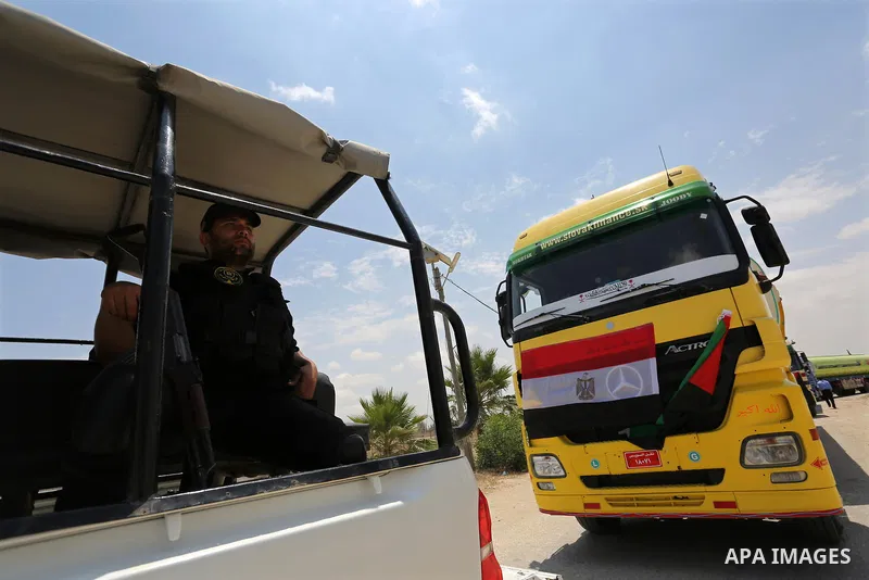 A member of Palestinian security forces stands guard as Egyptian trucks carrying fuel enter the southern Gaza Strip from Egypt through the Rafah border crossing on June 21, 2017. Egypt began to deliver a million litres o...