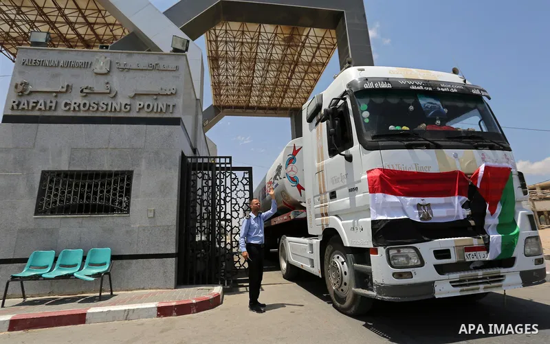A member of Palestinian security forces stands guard as Egyptian trucks carrying fuel enter the southern Gaza Strip from Egypt through the Rafah border crossing on June 21, 2017. Egypt began to deliver a million litres o...