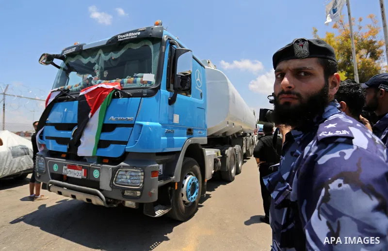 Palestinian security forces stand guard as Egyptian trucks carrying fuel arrive to Gaza's power plant in Nusseirat, in the central Gaza Strip after entering the southern Gaza Strip from Egypt through the Rafah border cro...