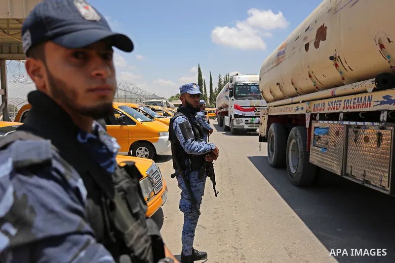 Palestinian security forces stand guard as Egyptian trucks carrying fuel arrive to Gaza's power plant in Nusseirat, in the central Gaza Strip after entering the southern Gaza Strip from Egypt through the Rafah border cro...