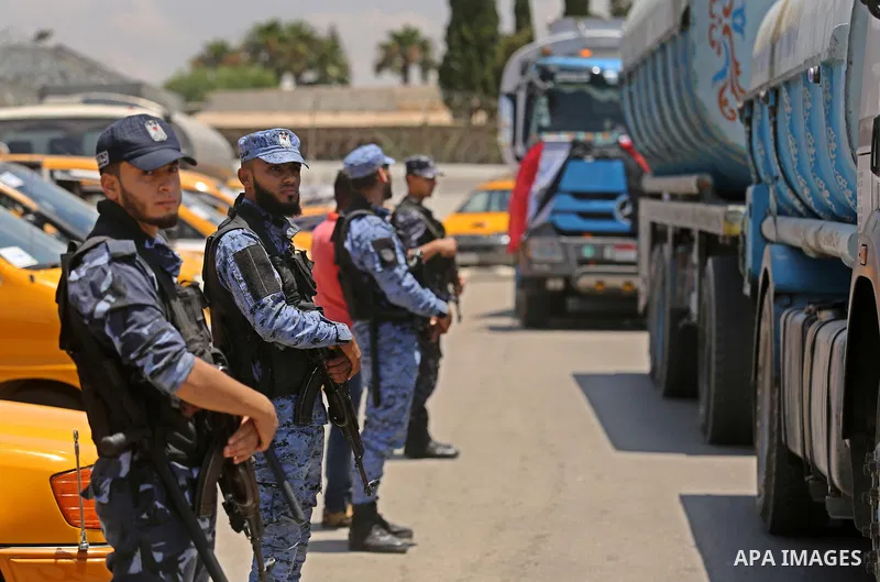 Palestinian security forces stand guard as Egyptian trucks carrying fuel arrive to Gaza's power plant in Nusseirat, in the central Gaza Strip after entering the southern Gaza Strip from Egypt through the Rafah border cro...