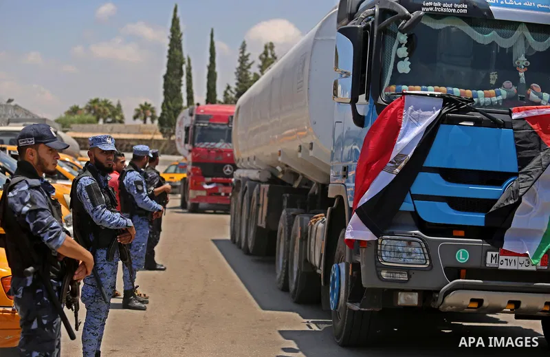 Palestinian security forces stand guard as Egyptian trucks carrying fuel arrive to Gaza's power plant in Nusseirat, in the central Gaza Strip after entering the southern Gaza Strip from Egypt through the Rafah border cro...