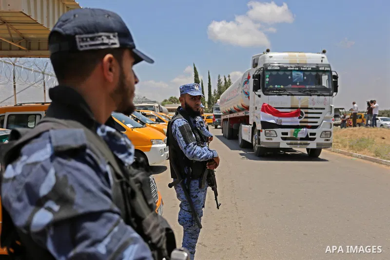 Palestinian security forces stand guard as Egyptian trucks carrying fuel arrive to Gaza's power plant in Nusseirat, in the central Gaza Strip after entering the southern Gaza Strip from Egypt through the Rafah border cro...
