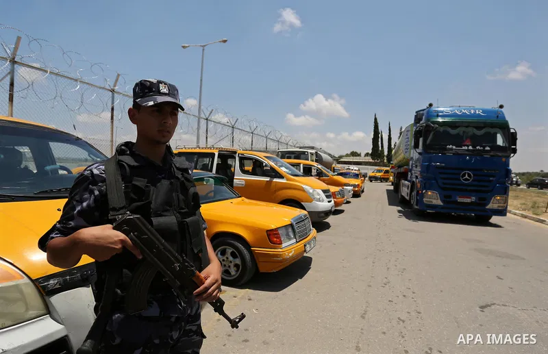 A member of Palestinian security forces stands guard as Egyptian trucks carrying fuel arrive to Gaza's power plant in Nusseirat, in the central Gaza Strip after entering the southern Gaza Strip from Egypt through the Raf...