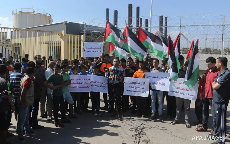Palestinians hold banners during a protest against the worsening crisis of power outages in front of Gaza's power plant in Nuseirat in the center of Gaza strip, on June 21, 2017. Egypt began to deliver a million litres o...