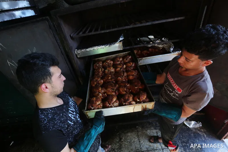 Palestinians prepare rice and meats as they wait for customers several hours before Iftar, the breaking of the day long Ramadan fast in Gaza City, on June 21, 2017. Muslims around the world refrain from eating, drinking...