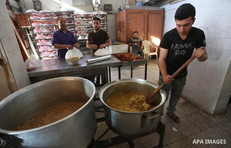 Palestinians prepare rice and meats as they wait for customers several hours before Iftar, the breaking of the day long Ramadan fast in Gaza City, on June 21, 2017. Muslims around the world refrain from eating, drinking...