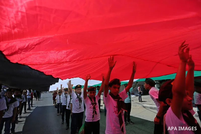 Palestinian Scout youths wave a large Palestinian flag in a protest marking the annual al-Quds Day, or Jerusalem Day, following Friday prayer in Gaza city June 23, 2017. Photo by Ashraf Amra