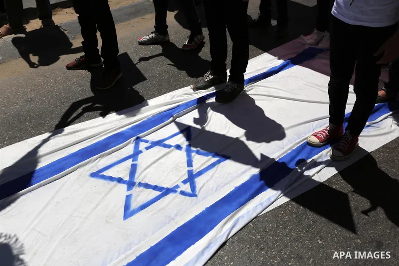 Palestinian children step on the Israeli flag in a protest marking the annual al-Quds Day, or Jerusalem Day, following Friday prayer in Gaza city June 23, 2017. Photo by Ashraf Amra