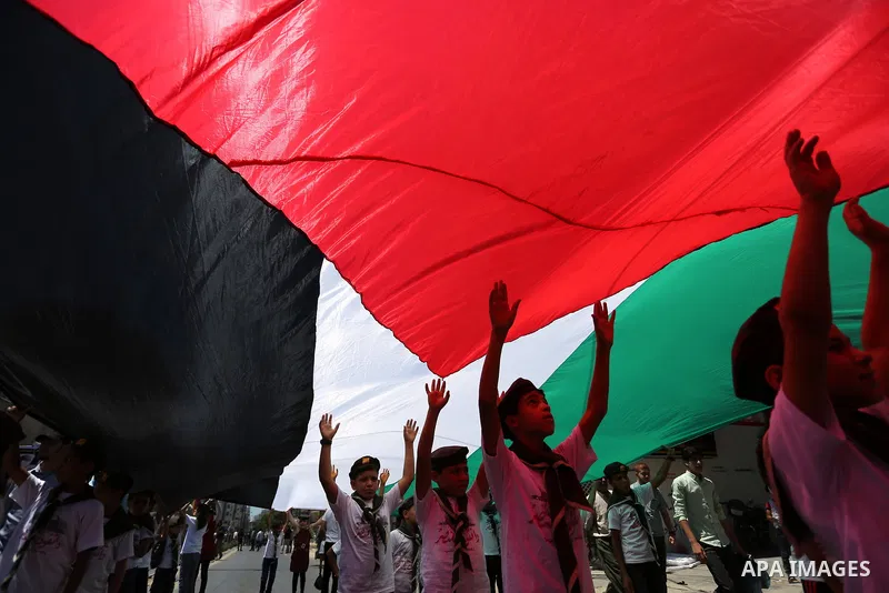 Palestinian Scout youths wave a large Palestinian flag in a protest marking the annual al-Quds Day, or Jerusalem Day, following Friday prayer in Gaza city June 23, 2017. Photo by Ashraf Amra