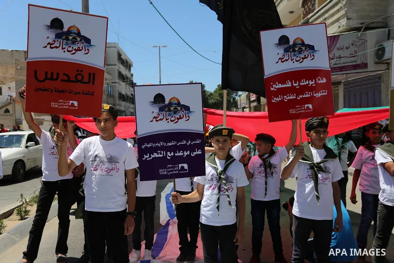 Palestinian Scout youths hold placards in a protest marking the annual al-Quds Day, or Jerusalem Day, following Friday prayer in Gaza city June 23, 2017. Photo by Ashraf Amra