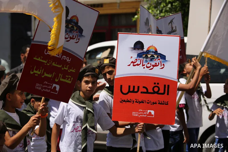 Palestinian Scout youths hold placards in a protest marking the annual al-Quds Day, or Jerusalem Day, following Friday prayer in Gaza city June 23, 2017. Photo by Ashraf Amra
