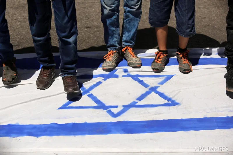 Palestinian children step on the Israeli flag in a protest marking the annual al-Quds Day, or Jerusalem Day, following Friday prayer in Gaza city June 23, 2017. Photo by Ashraf Amra