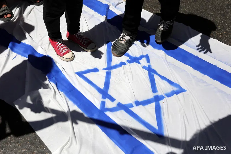 Palestinian children step on the Israeli flag in a protest marking the annual al-Quds Day, or Jerusalem Day, following Friday prayer in Gaza city June 23, 2017. Photo by Ashraf Amra