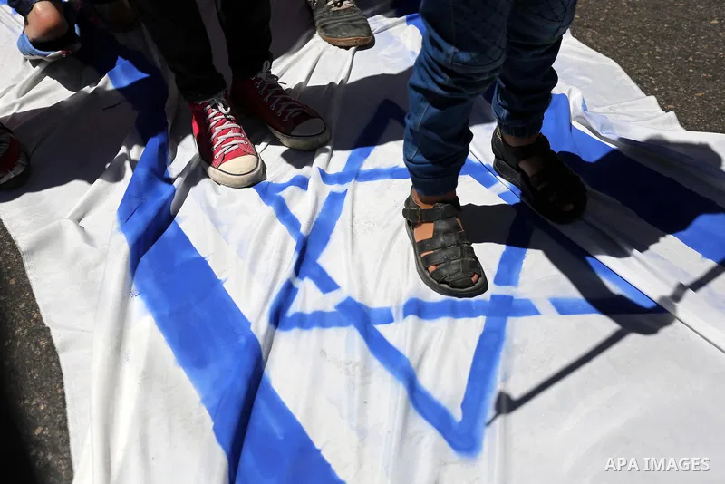 Palestinian children step on the Israeli flag in a protest marking the annual al-Quds Day, or Jerusalem Day, following Friday prayer in Gaza city June 23, 2017. Photo by Ashraf Amra