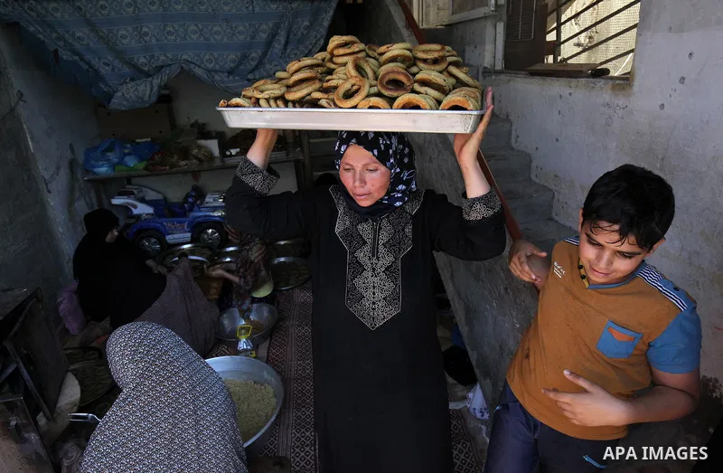 A Palestinian family make traditional date-filled cookies in preparation for the Eid al-Fitr holiday at their home in Rafah, in the southern Gaza Strip, on June 23, 2017. Muslims around the world are preparing to celebra...