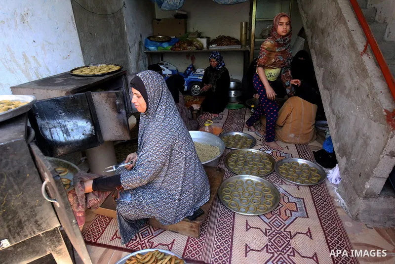 A Palestinian family make traditional date-filled cookies in preparation for the Eid al-Fitr holiday at their home in Rafah, in the southern Gaza Strip, on June 23, 2017. Muslims around the world are preparing to celebra...