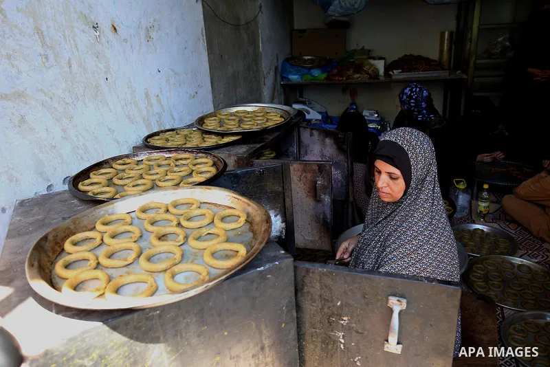 A Palestinian family make traditional date-filled cookies in preparation for the Eid al-Fitr holiday at their home in Rafah, in the southern Gaza Strip, on June 23, 2017. Muslims around the world are preparing to celebra...