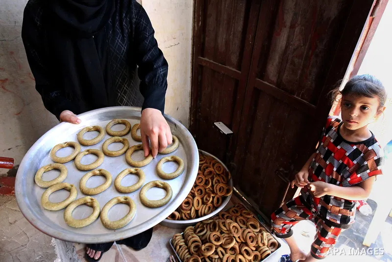A Palestinian family make traditional date-filled cookies in preparation for the Eid al-Fitr holiday at their home in Rafah, in the southern Gaza Strip, on June 23, 2017. Muslims around the world are preparing to celebra...