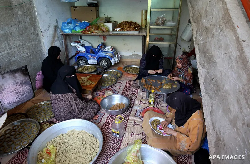 A Palestinian family make traditional date-filled cookies in preparation for the Eid al-Fitr holiday at their home in Rafah, in the southern Gaza Strip, on June 23, 2017. Muslims around the world are preparing to celebra...