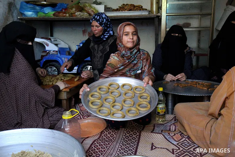 A Palestinian girl makes traditional date-filled cookies with her family in preparation for the Eid al-Fitr holiday at their home in Rafah, in the southern Gaza Strip, on June 23, 2017. Muslims around the world are prepa...