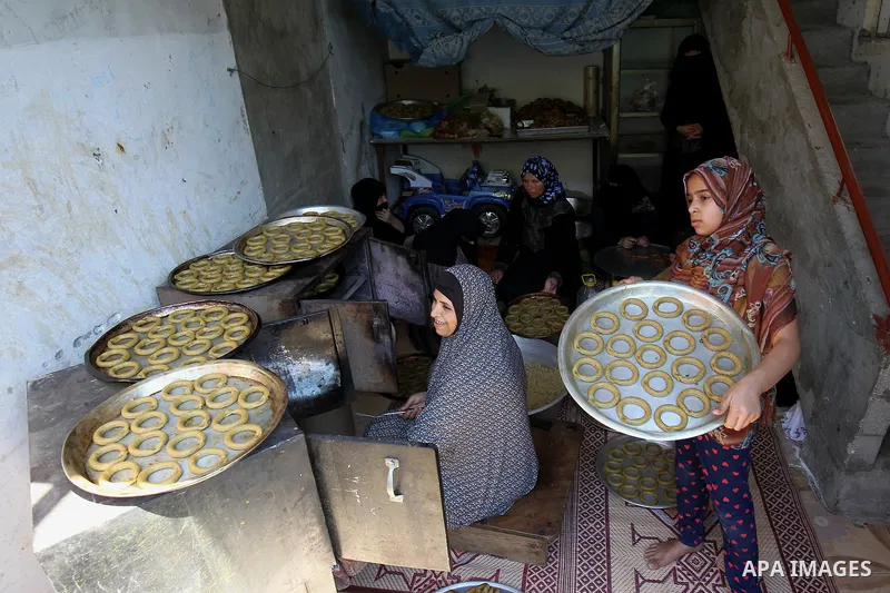 A Palestinian family make traditional date-filled cookies in preparation for the Eid al-Fitr holiday at their home in Rafah, in the southern Gaza Strip, on June 23, 2017. Muslims around the world are preparing to celebra...