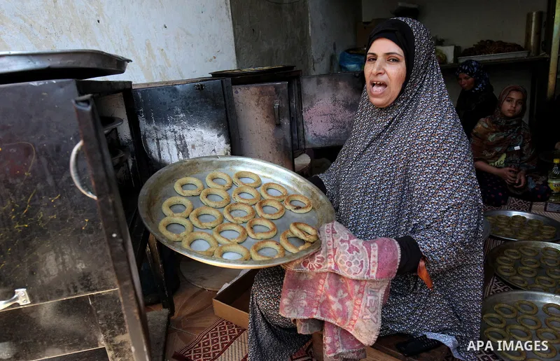A Palestinian family make traditional date-filled cookies in preparation for the Eid al-Fitr holiday at their home in Rafah, in the southern Gaza Strip, on June 23, 2017. Muslims around the world are preparing to celebra...