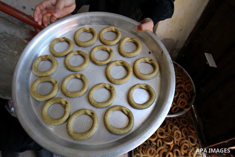 A Palestinian family make traditional date-filled cookies in preparation for the Eid al-Fitr holiday at their home in Rafah, in the southern Gaza Strip, on June 23, 2017. Muslims around the world are preparing to celebra...