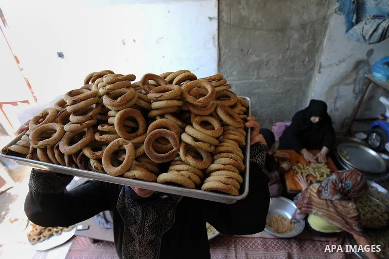 A Palestinian family make traditional date-filled cookies in preparation for the Eid al-Fitr holiday at their home in Rafah, in the southern Gaza Strip, on June 23, 2017. Muslims around the world are preparing to celebra...