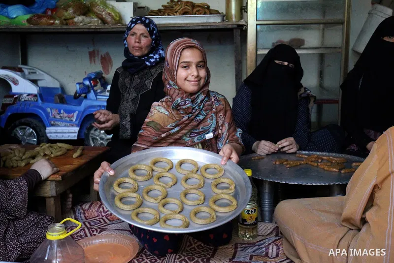 A Palestinian girl makes traditional date-filled cookies with her family in preparation for the Eid al-Fitr holiday at their home in Rafah, in the southern Gaza Strip, on June 23, 2017. Muslims around the world are prepa...