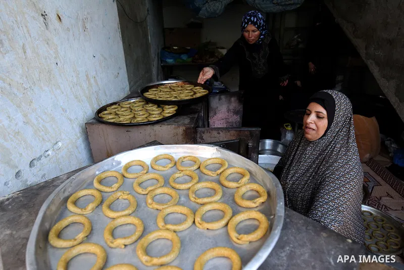 A Palestinian family make traditional date-filled cookies in preparation for the Eid al-Fitr holiday at their home in Rafah, in the southern Gaza Strip, on June 23, 2017. Muslims around the world are preparing to celebra...