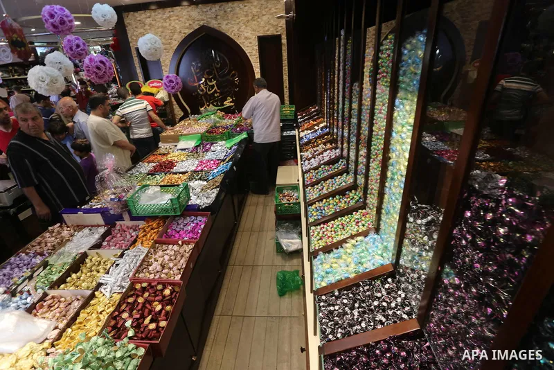 Palestinians sell chocolate at a shop ahead of the Eid al-Fitr holiday, in Gaza city, on JUne 23, 2017. Eid al-Fitr marks the end of Muslim's holy fasting month of Ramadan when faithfuls abstain from eating, drinking, sm...