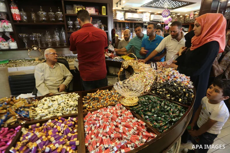 Palestinians sell chocolate at a shop ahead of the Eid al-Fitr holiday, in Gaza city, on JUne 23, 2017. Eid al-Fitr marks the end of Muslim's holy fasting month of Ramadan when faithfuls abstain from eating, drinking, sm...