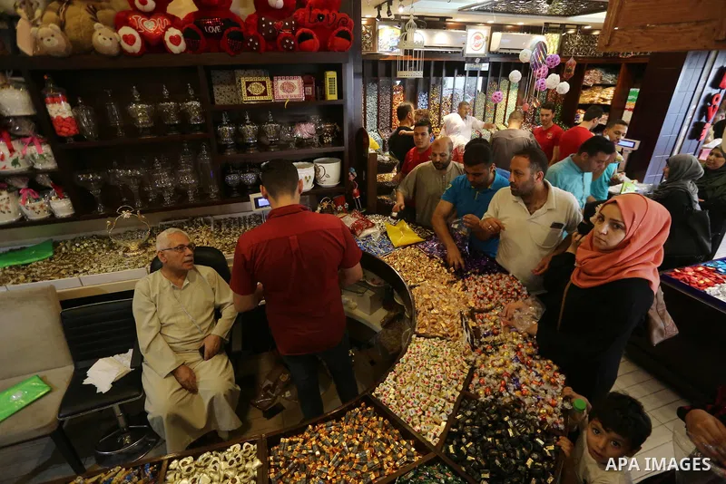 Palestinians sell chocolate at a shop ahead of the Eid al-Fitr holiday, in Gaza city, on JUne 23, 2017. Eid al-Fitr marks the end of Muslim's holy fasting month of Ramadan when faithfuls abstain from eating, drinking, sm...