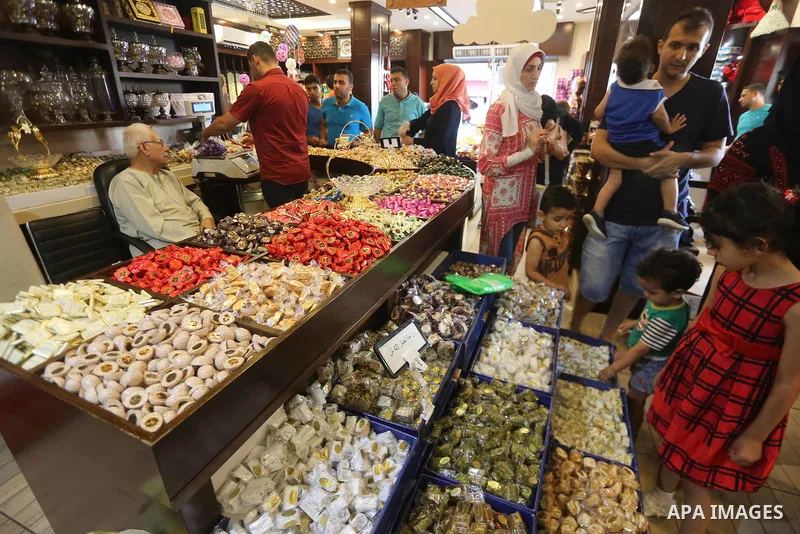 Palestinians sell chocolate at a shop ahead of the Eid al-Fitr holiday, in Gaza city, on JUne 23, 2017. Eid al-Fitr marks the end of Muslim's holy fasting month of Ramadan when faithfuls abstain from eating, drinking, sm...