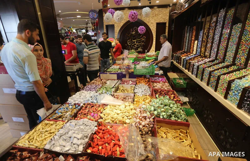 Palestinians sell chocolate at a shop ahead of the Eid al-Fitr holiday, in Gaza city, on JUne 23, 2017. Eid al-Fitr marks the end of Muslim's holy fasting month of Ramadan when faithfuls abstain from eating, drinking, sm...