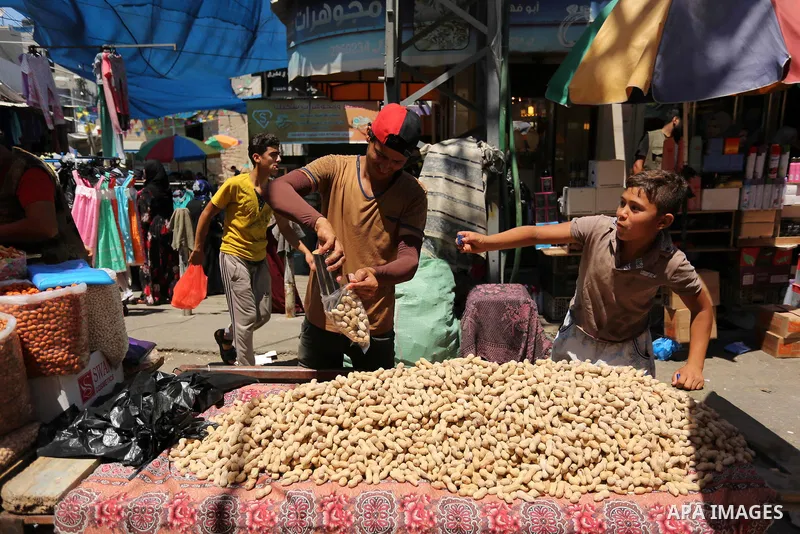A Palestinian vendor sells nuts at a market ahead of Eid al-Fitr holiday, in Gaza city on June 24, 2017. Eid al-Fitr marks the end of Muslim's holy fasting month of Ramadan when faithfuls abstain from eating, drinking, s...