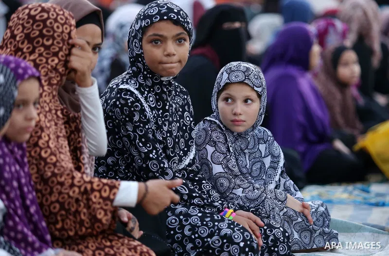 Palestinian Muslim girls attend Eid al-Fitr prayers in Gaza City June 25, 2017. Eid al-Fitr marks the end of Muslim's holy fasting month of Ramadan when faithfuls abstain from eating, drinking, smoking and sexual activit...