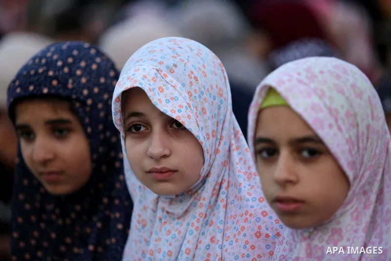 Palestinian Muslim girls attend Eid al-Fitr prayers in Gaza City June 25, 2017. Eid al-Fitr marks the end of Muslim's holy fasting month of Ramadan when faithfuls abstain from eating, drinking, smoking and sexual activit...