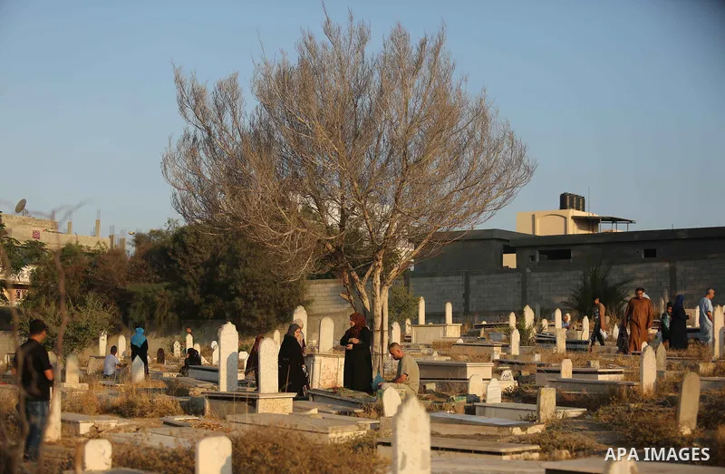 Palestinians visit the grave of their relative on the first day of Eid al-Fitr prayers, at a cemetery in Gaza City June 25, 2017. Photo by Ashraf Amra