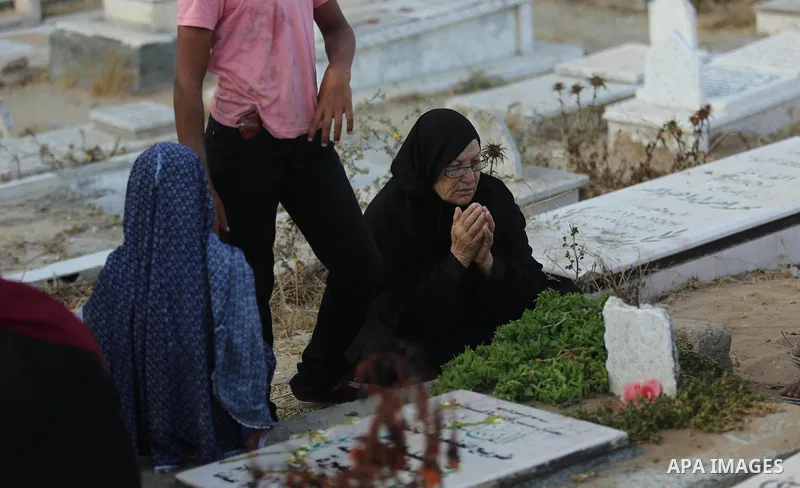 Palestinians visit the grave of their relative on the first day of Eid al-Fitr prayers, at a cemetery in Gaza City June 25, 2017. Photo by Ashraf Amra