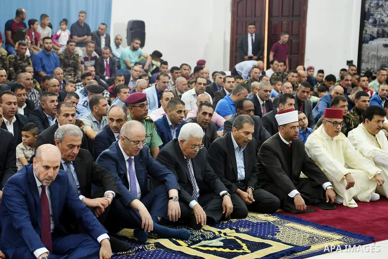 Palestinian President Mahmoud Abbas and his Prime Minister Rami Hamdallah attend Eid al-Fitr prayers, in the West Bank city of Ramallah on June 25, 2017. Photo by Thaer Ganaim