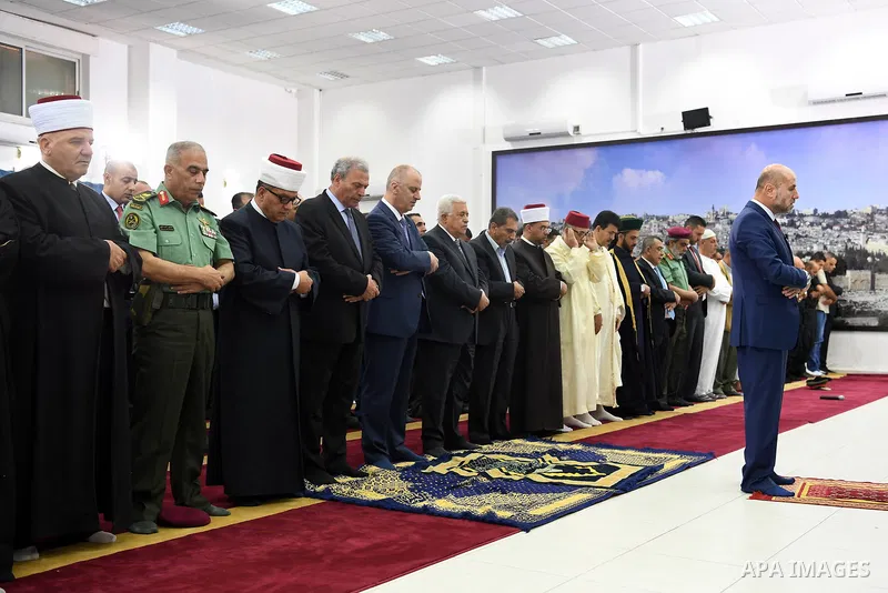 Palestinian President Mahmoud Abbas and his Prime Minister Rami Hamdallah perform Eid al-Fitr prayers, in the West Bank city of Ramallah on June 25, 2017. Photo by Thaer Ganaim